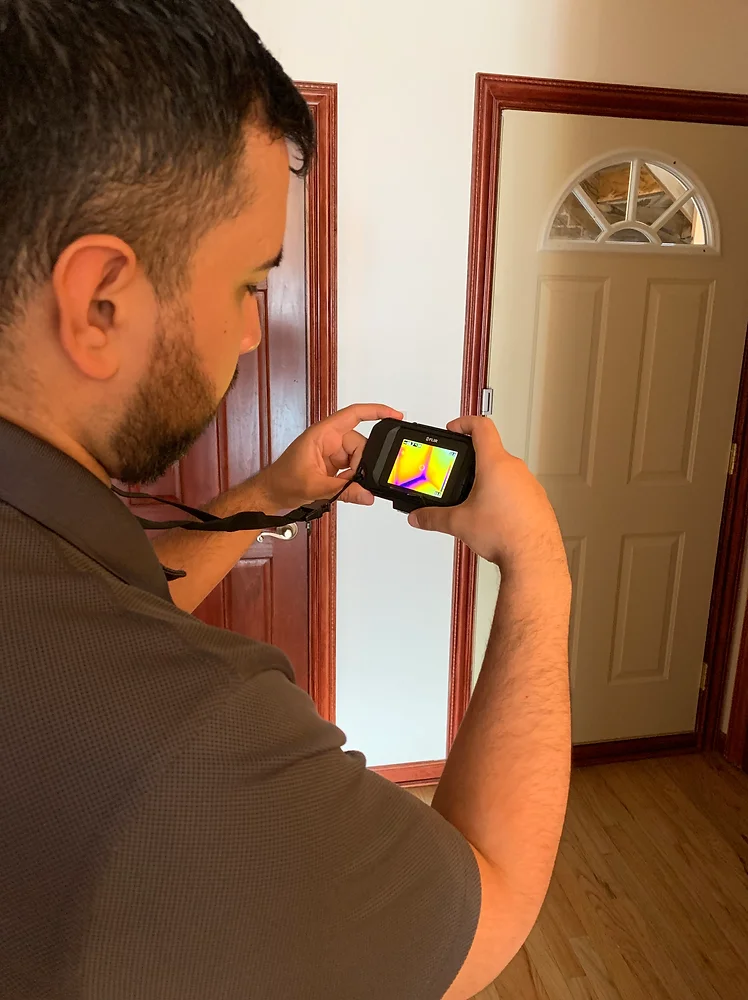 Home Inspector using thermal image camera during inspection